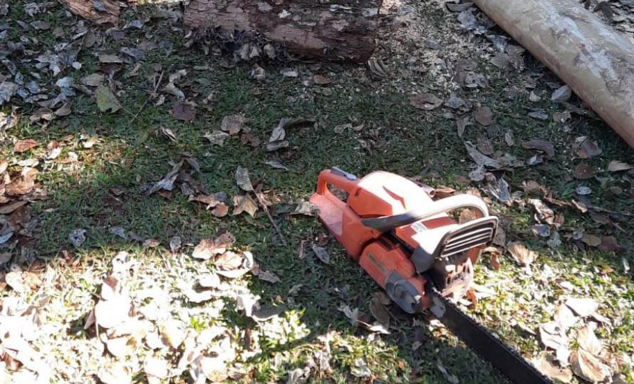 SERRA ELÉTRICA AO LADO DE MADEIRAS NO CHÃO