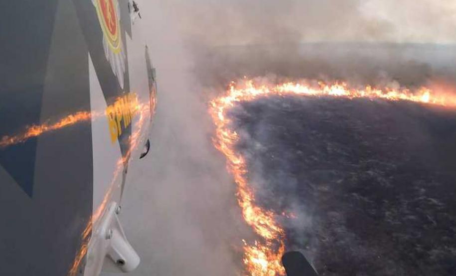 Foto de helicóptero sobrevoando incêndio