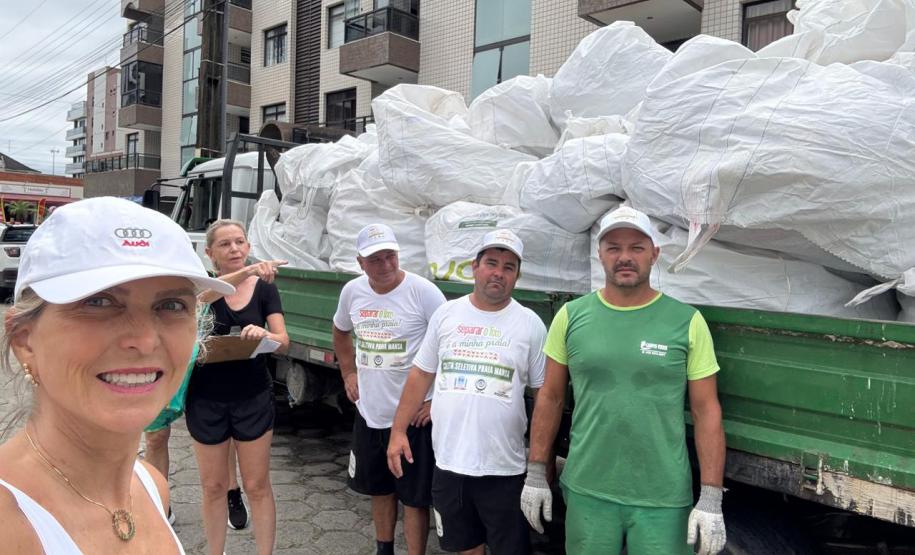 Foto de pessoas em frente a caminhão de lixo