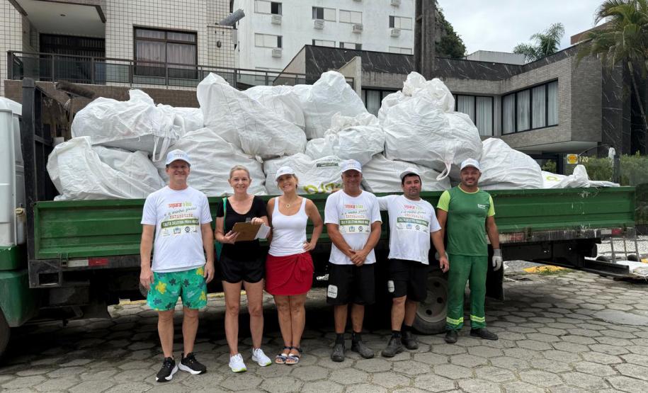 Foto de pessoas em frente a caminhão de lixo