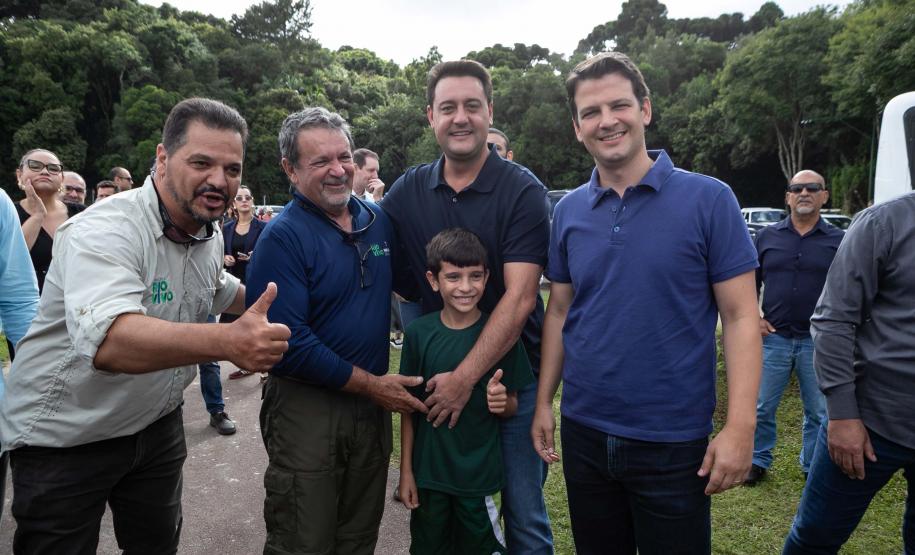 Foto de autoridades e crianças durante soltura de peixes