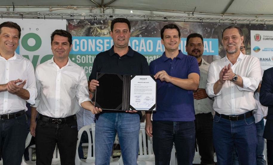 Foto de autoridades e crianças durante soltura de peixes