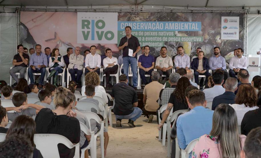 Foto de autoridades e crianças durante soltura de peixes