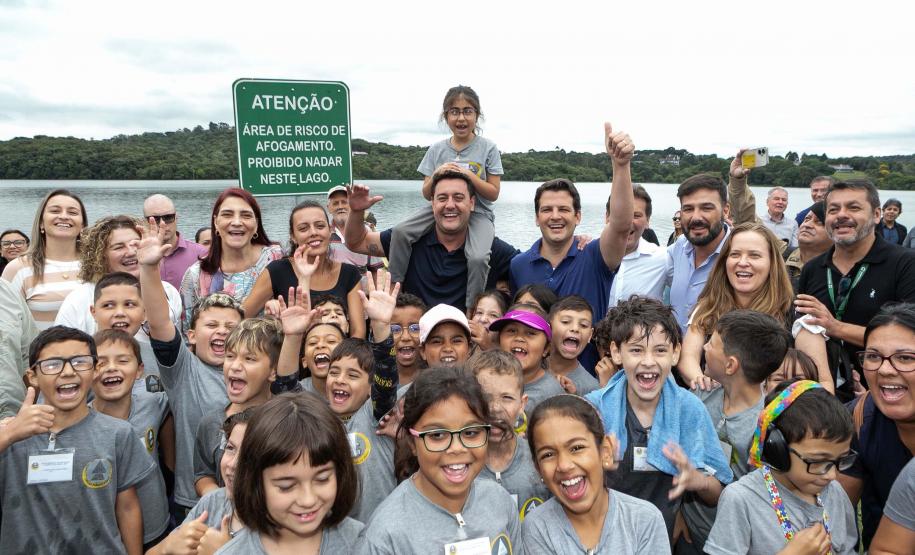 Foto de autoridades e crianças durante soltura de peixes