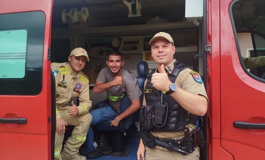 Foto de bombeiros com o jovem resgatado